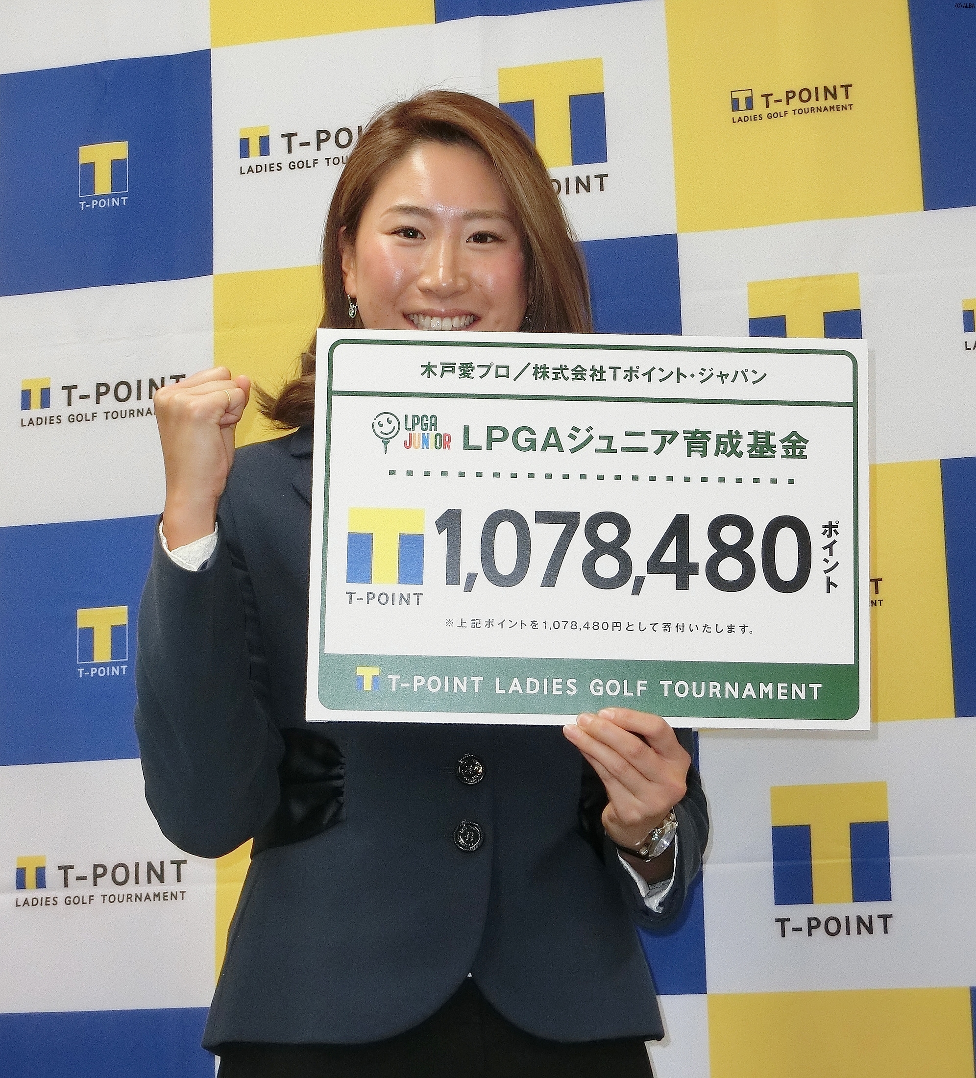 寄付金を手に笑顔を見せる木戸愛