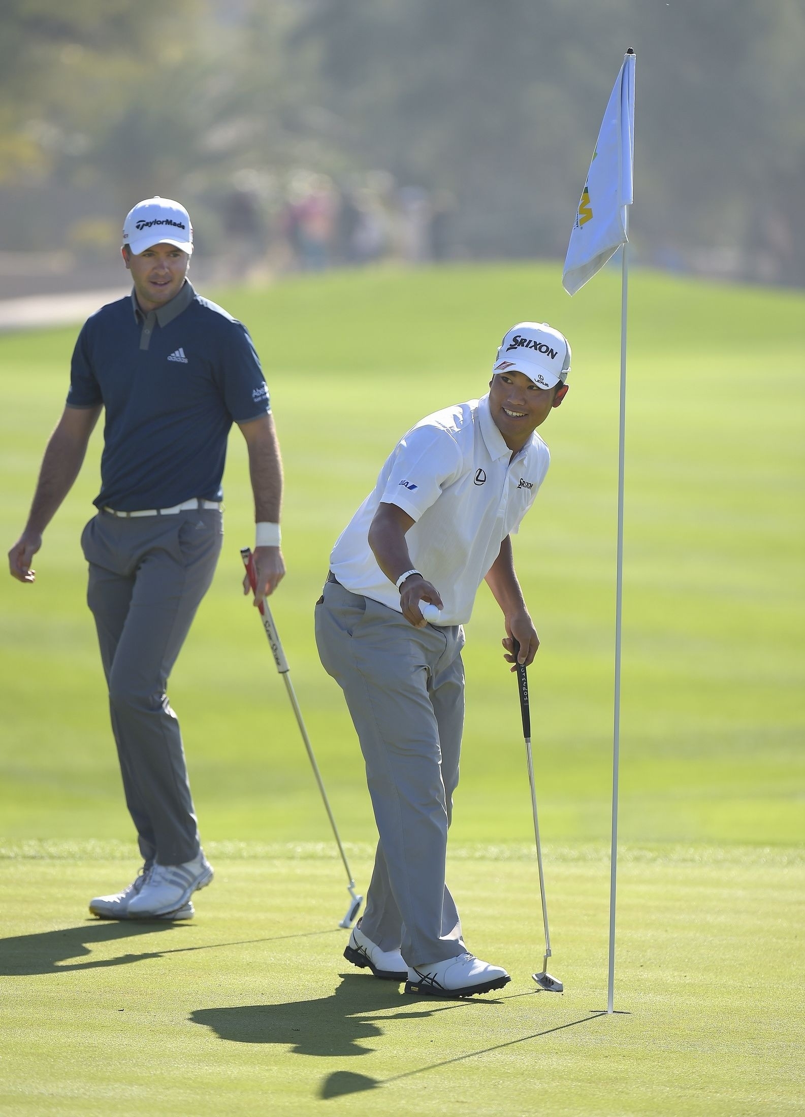 笑顔でボールをカップから拾い上げる松山(Photo by Stan BadzPGA TOUR)