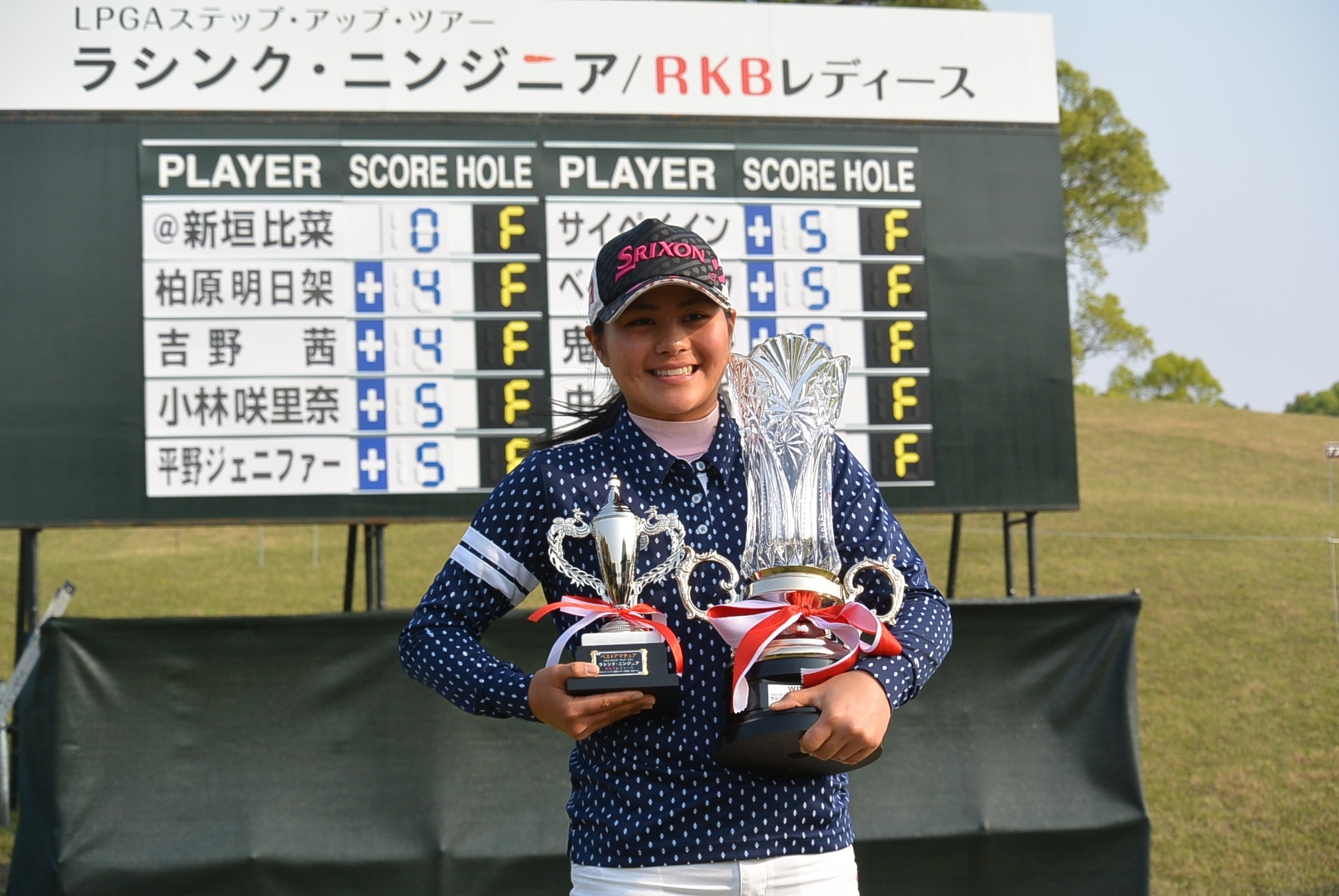 優勝杯とベストアマチュアトロフィを抱えて笑顔を見せる新垣（写真提供：LPGA）