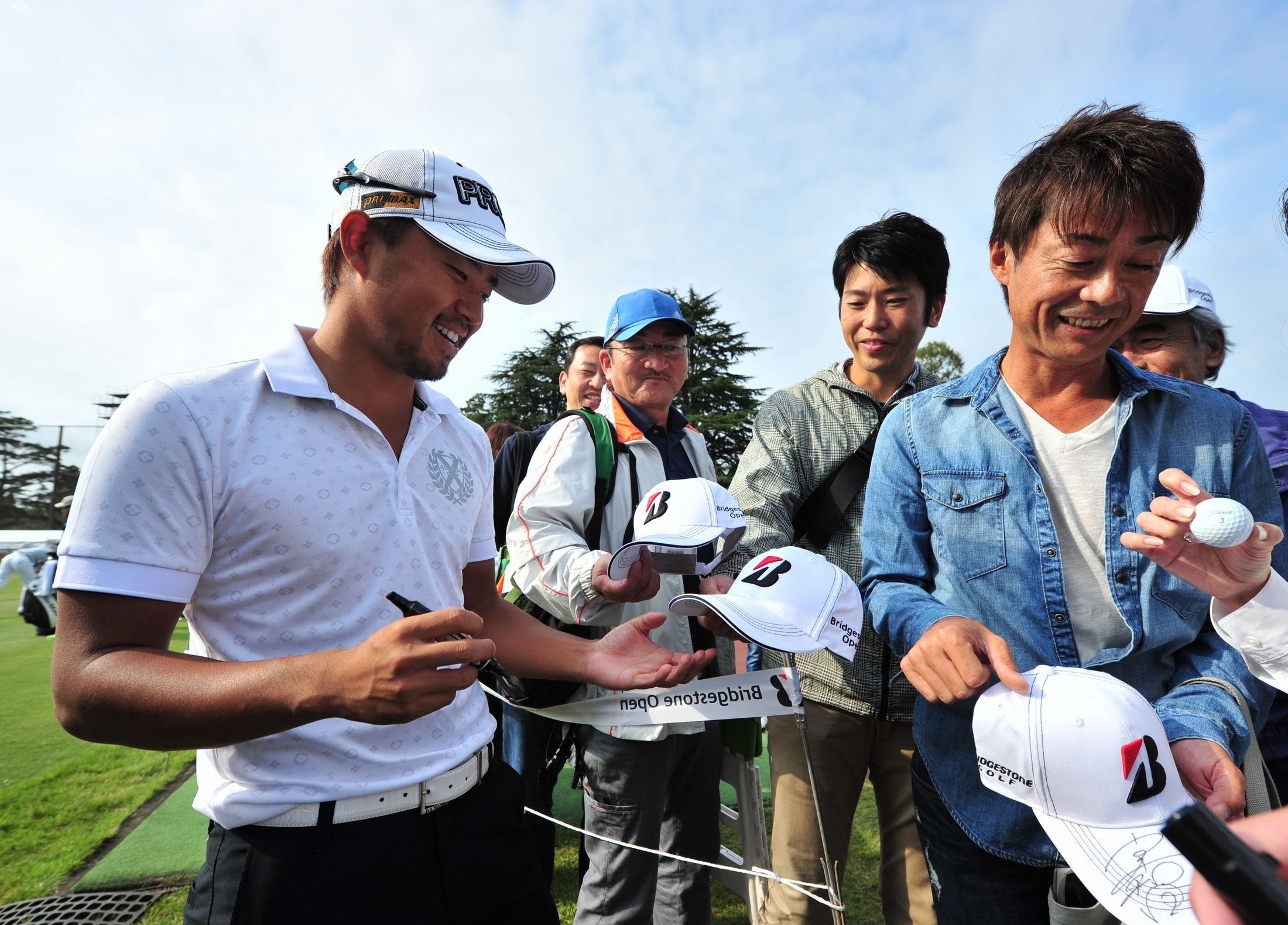 小平、ギャラリーからサインを求められ笑顔でペンを走らせた（撮影：岩井康博）