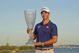 自由の女神をバックにトロフィを掲げるスコット(Photo by Chris CondonPGA TOUR)