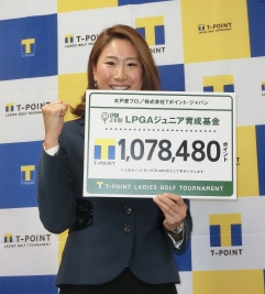 寄付金を手に笑顔を見せる木戸愛