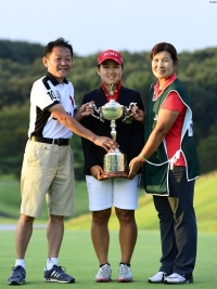 優勝カップを掲げ笑顔を見せる畑岡奈紗と父・仁一さん、キャディも務めた母・博美さん(撮影:上山敬太)