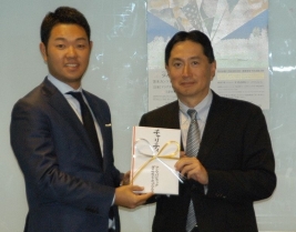 三菱商事・広報部長の判治孝之(右)から選手会副会長の薗田峻輔へ目録が贈られた(提供:大会事務局)