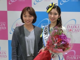 ミス沖縄の町田満彩智さん(右)から花束を手渡されるテレサ・ルー(撮影:秋田義和)